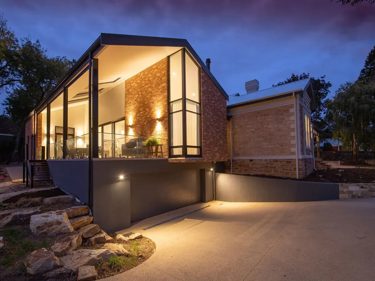 A modern house facade lit from within at dusk