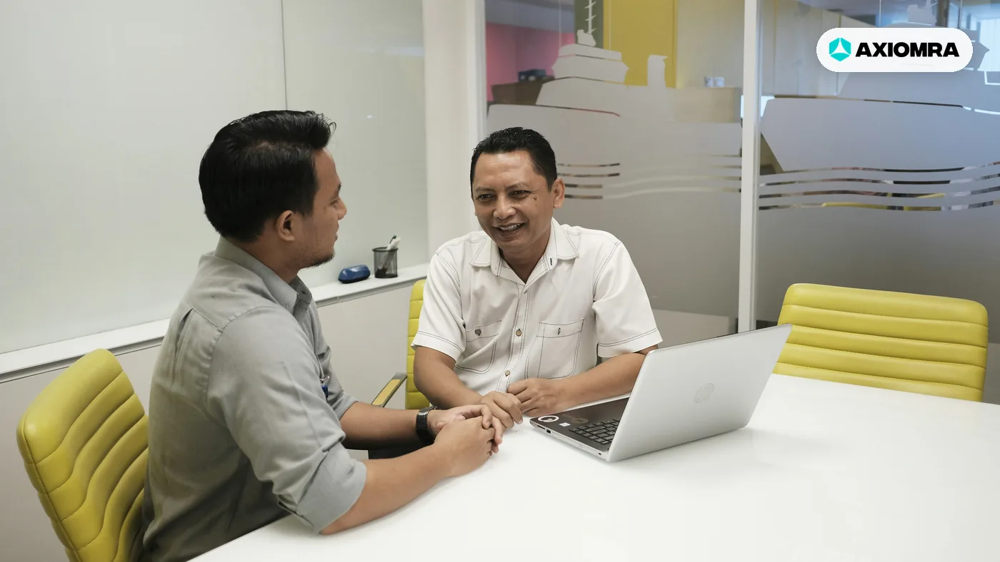 Two people in a meeting room talking across a laptop, the kind of sales call the flow ends with
