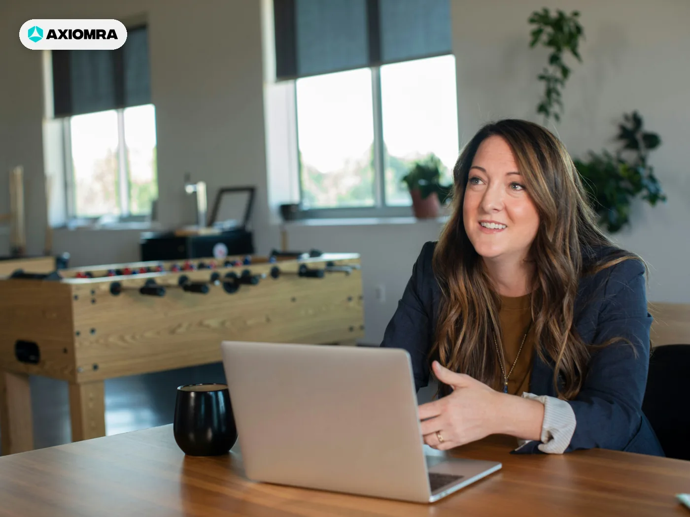 A salesperson at a laptop in an open office, talking through a qualified inquiry