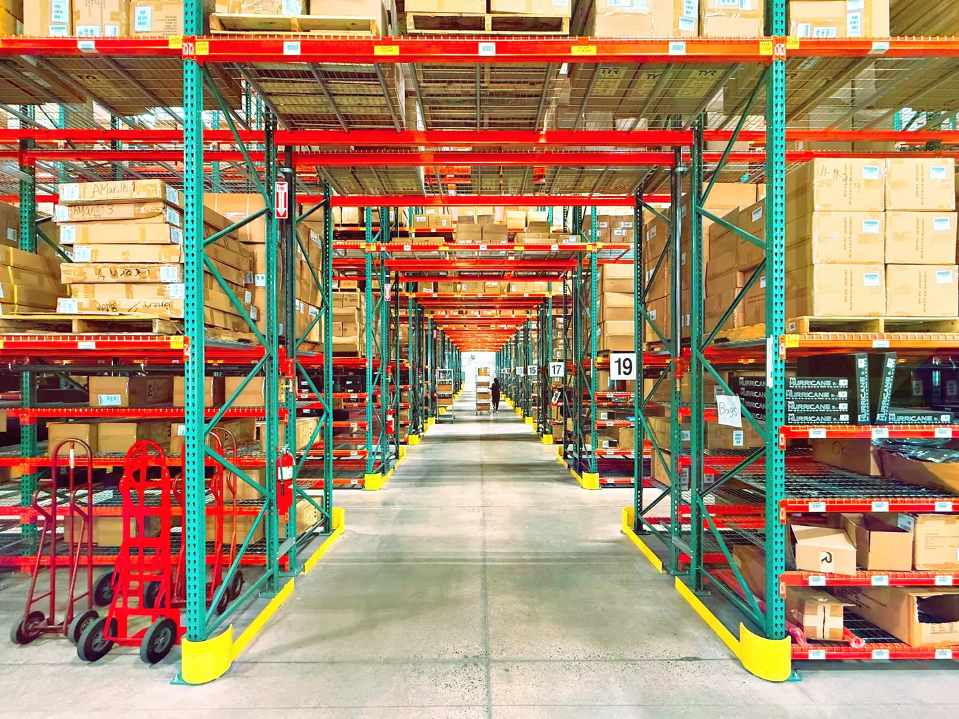 Long rows of tall warehouse shelves stacked with cardboard boxes