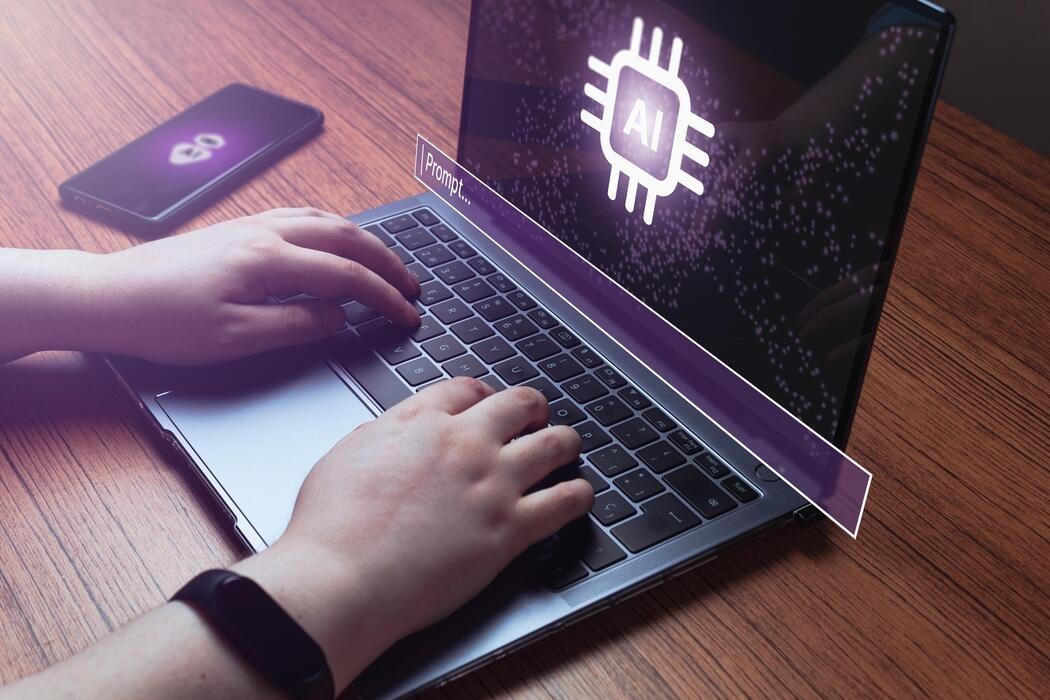 Hands typing a prompt into an agent interface open on a laptop