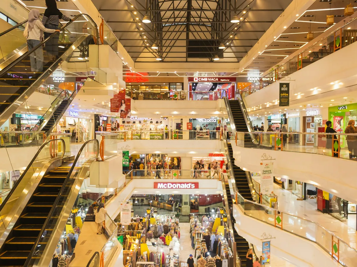 Escalators and shop fronts across several levels of a busy shopping centre