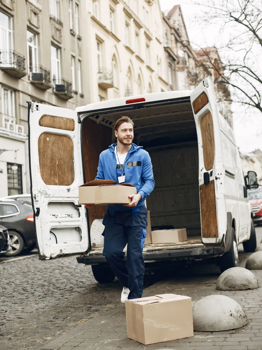 A courier unloading parcels from the back of a delivery van