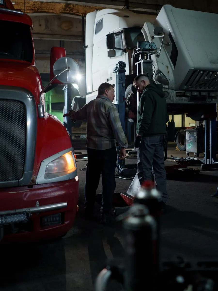 Mechanics working on a truck cab in a workshop