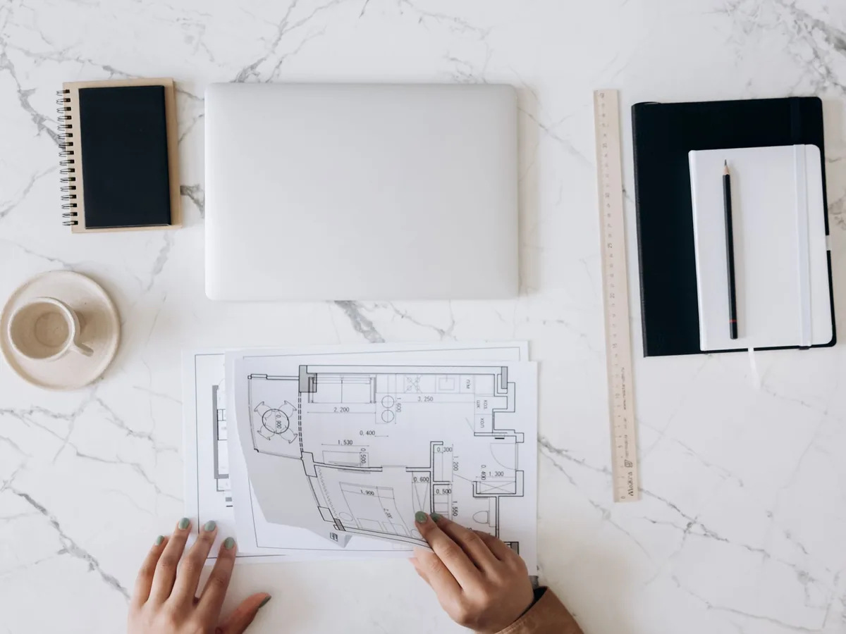 An architect's desk with blueprints, ruler and drawing tools
