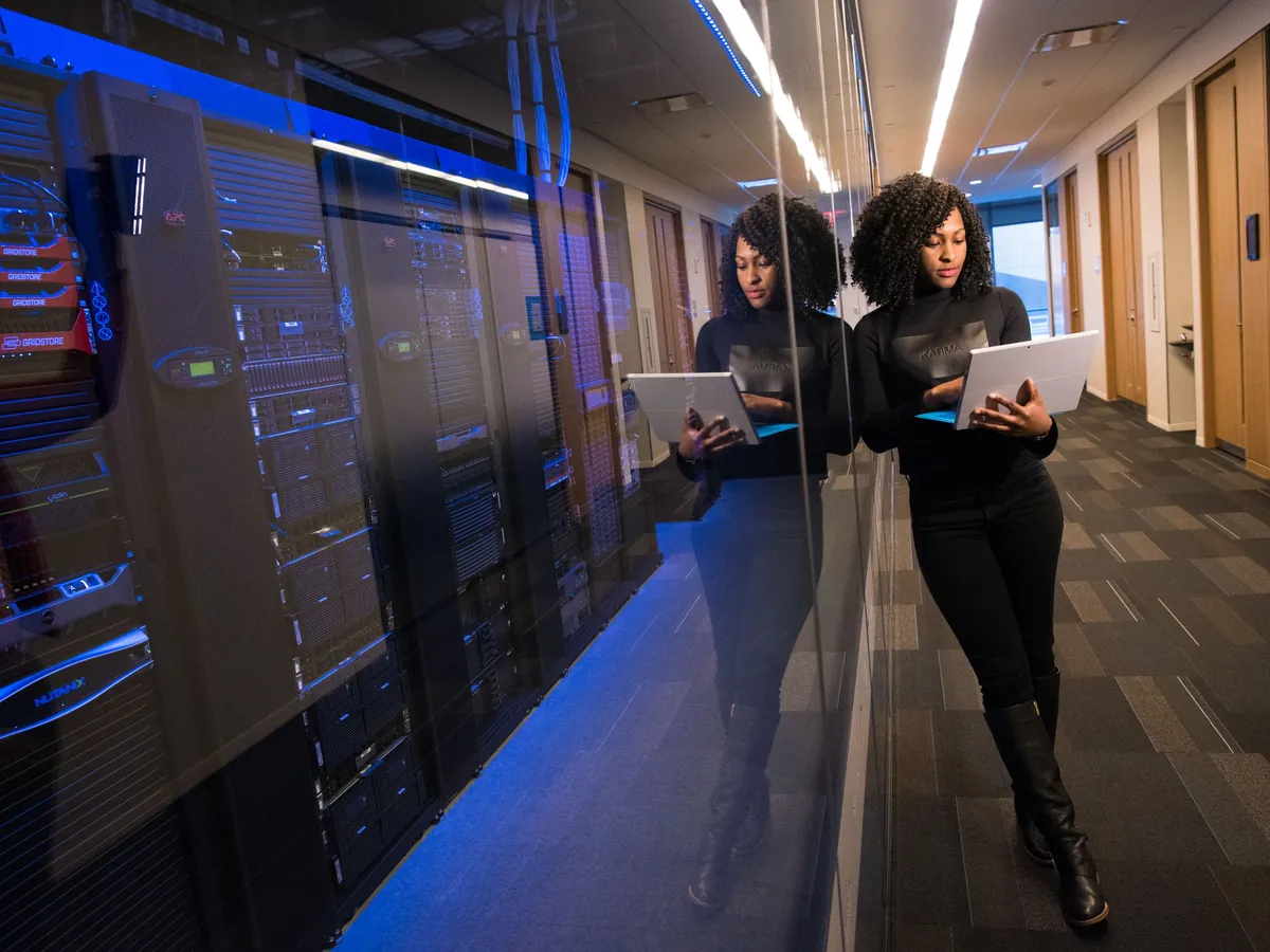 An engineer working on platform code beside server racks
