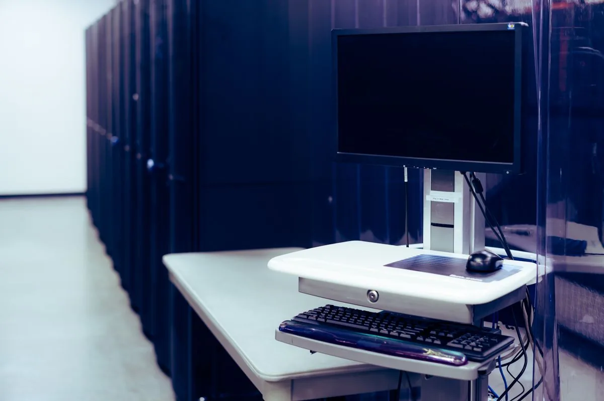 A modern workstation beside data-centre server racks
