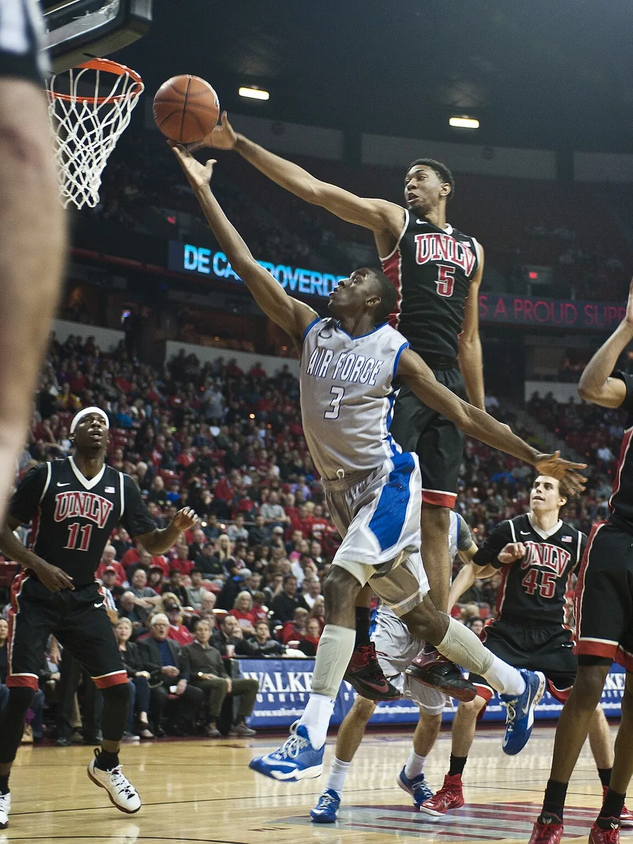 A basketball player rising to the hoop