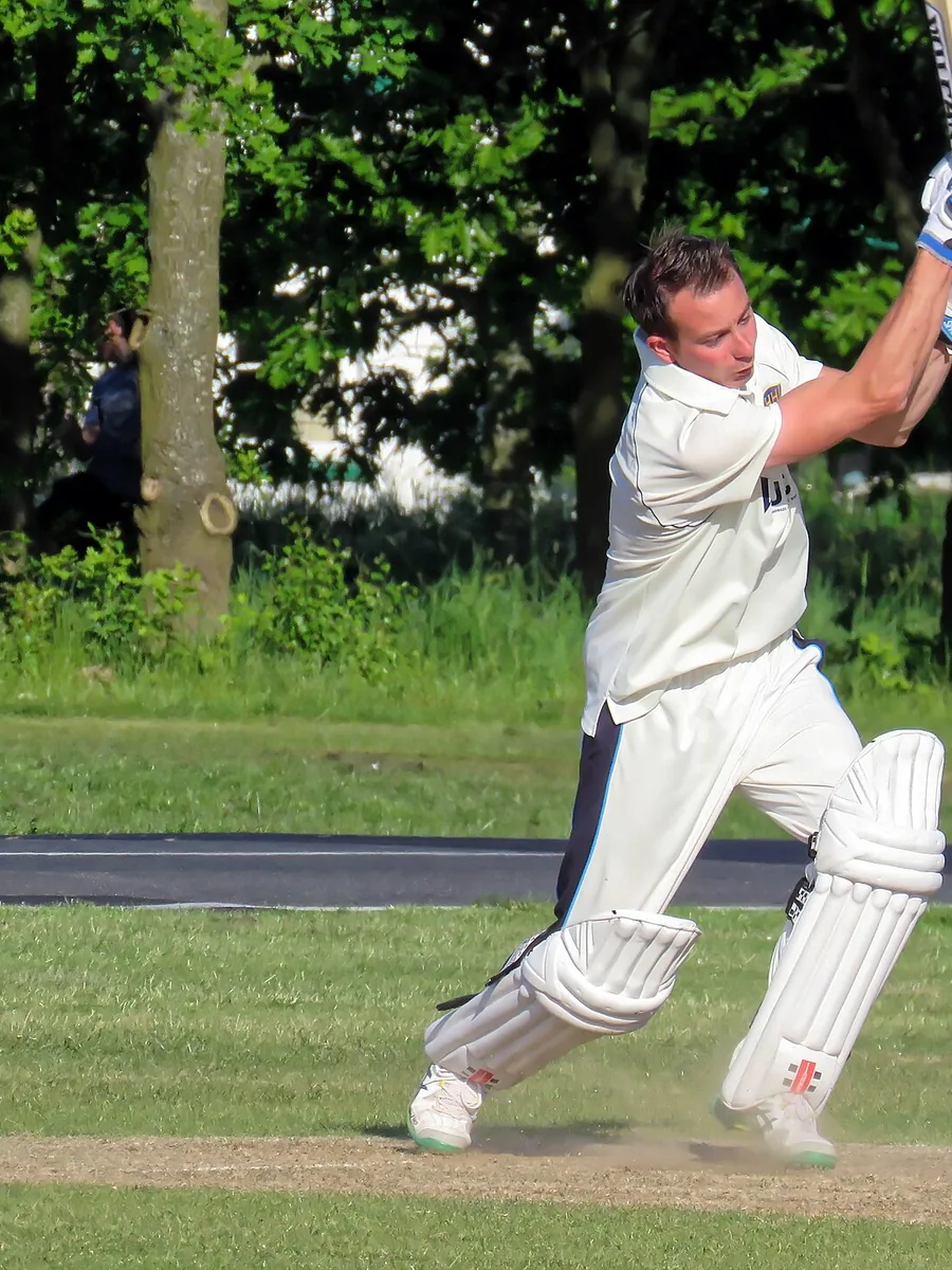 A batsman playing a shot during a cricket match