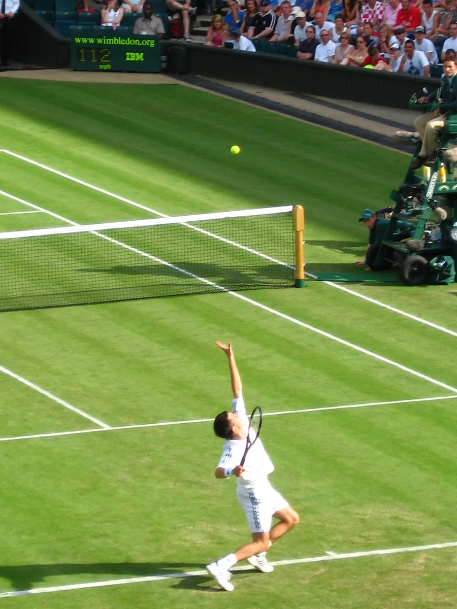 A tennis player serving on a hard court