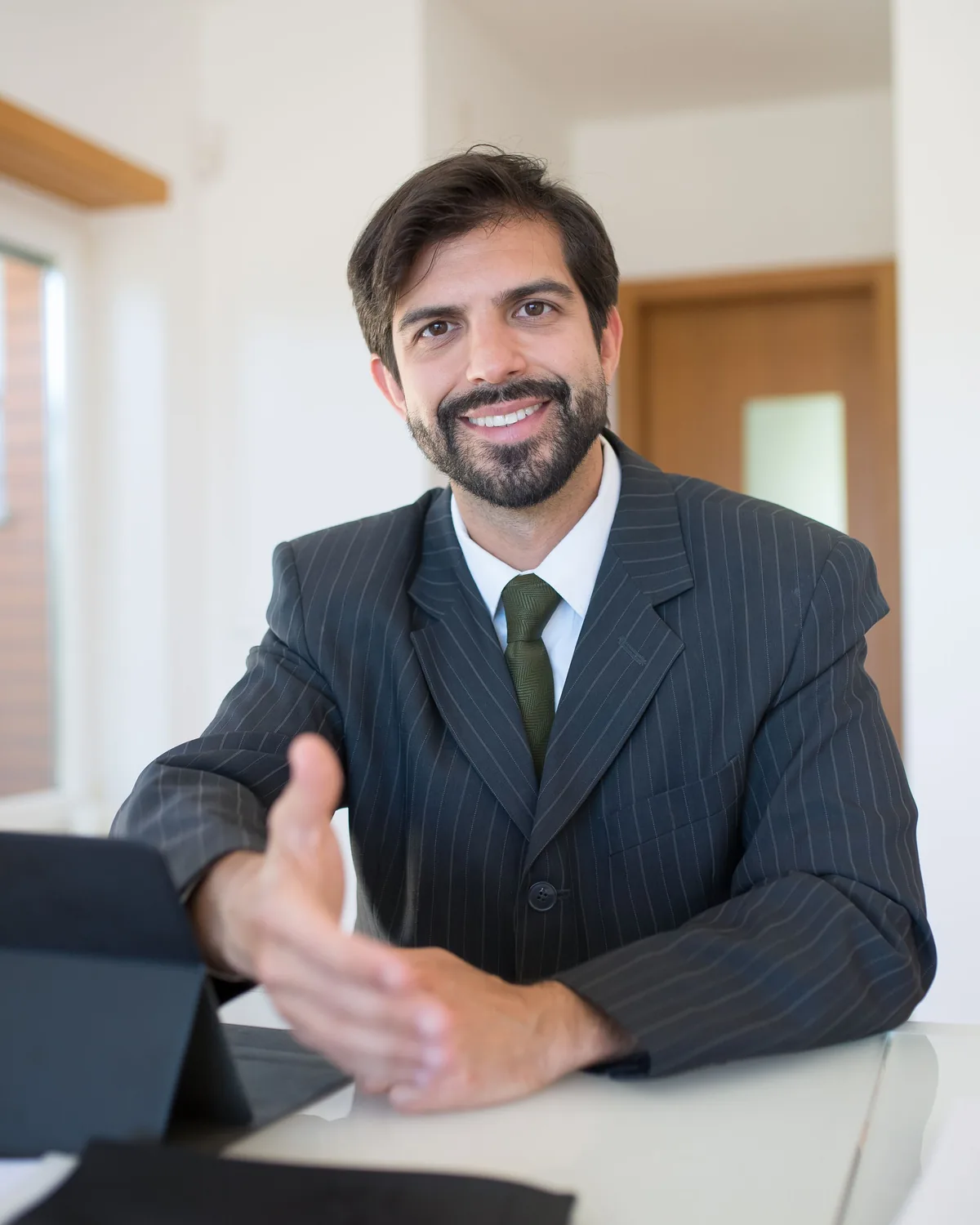 A real estate agent in a blue suit outside a property