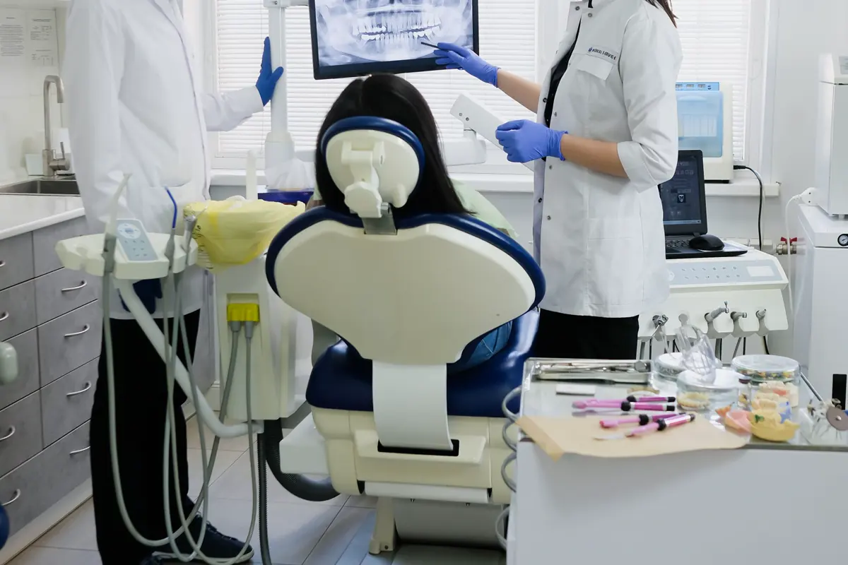 A dental team examining a patient with modern equipment