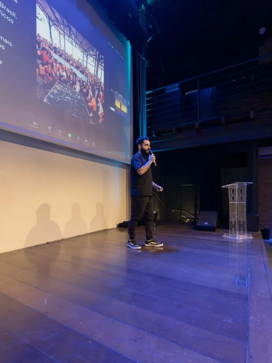 A speaker presenting on stage to a conference audience