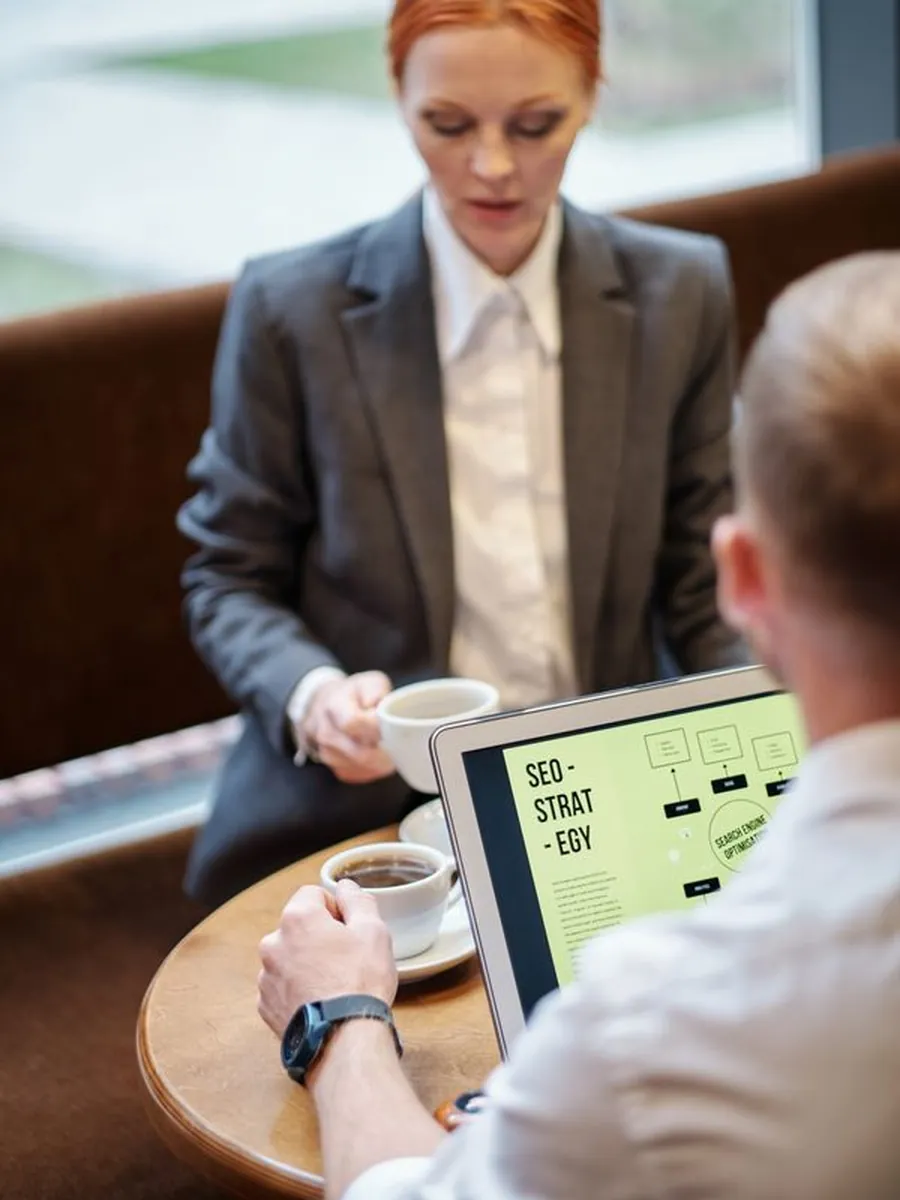 Two strategists discussing an SEO plan over coffee