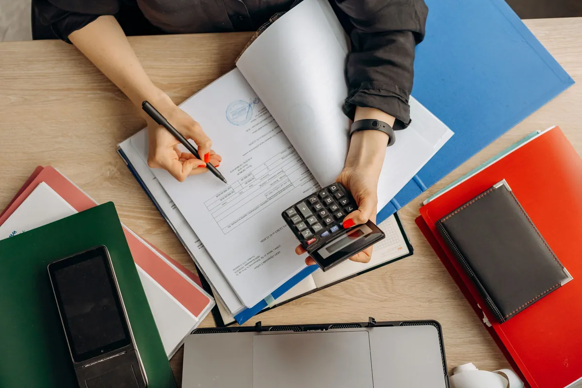 An accountant working through financial statements with a calculator