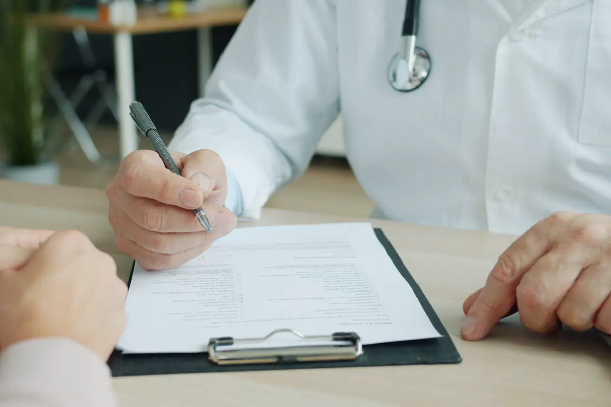 A doctor and patient reviewing medical paperwork together