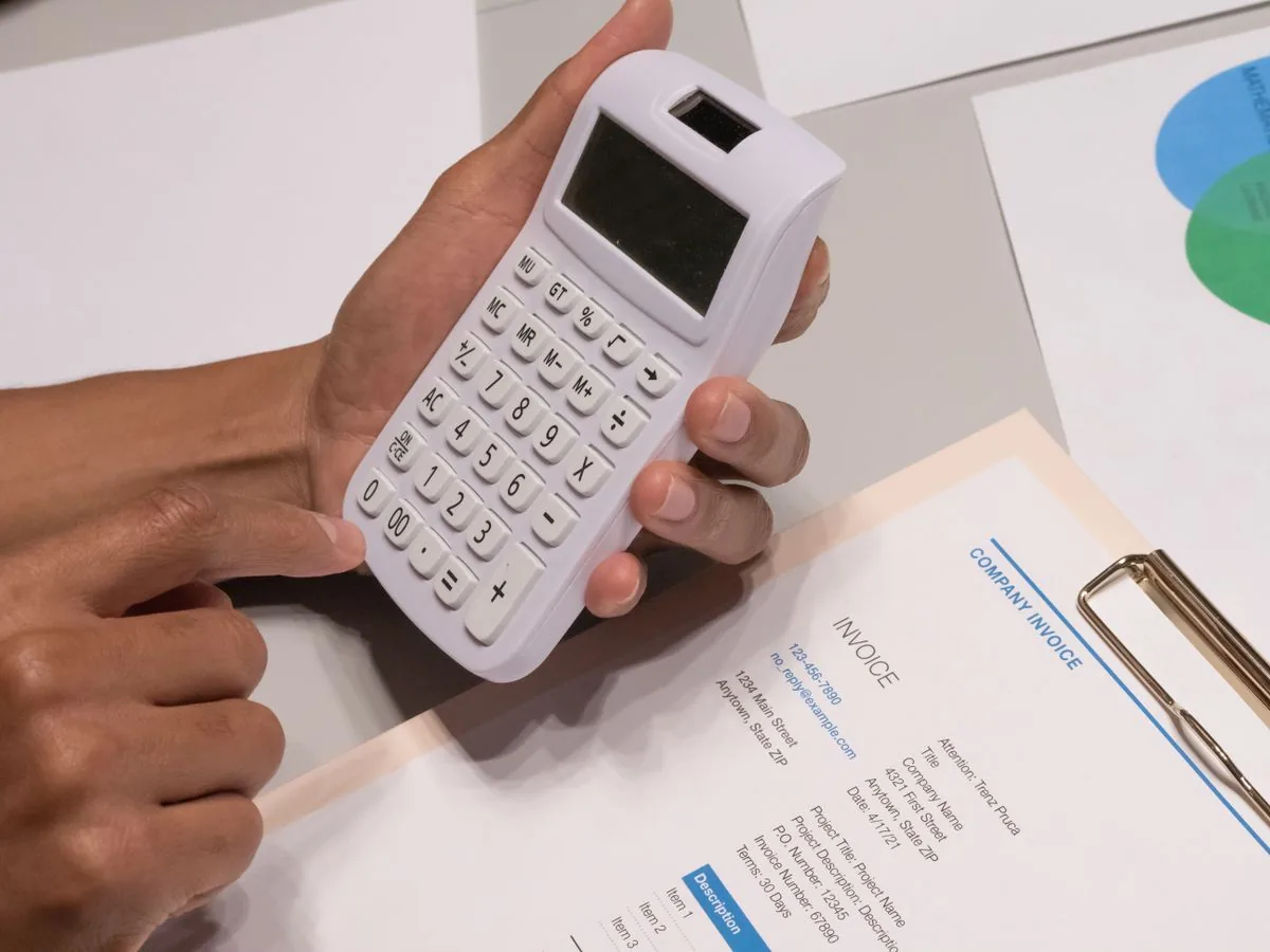 An accountant working through legal invoices with a calculator