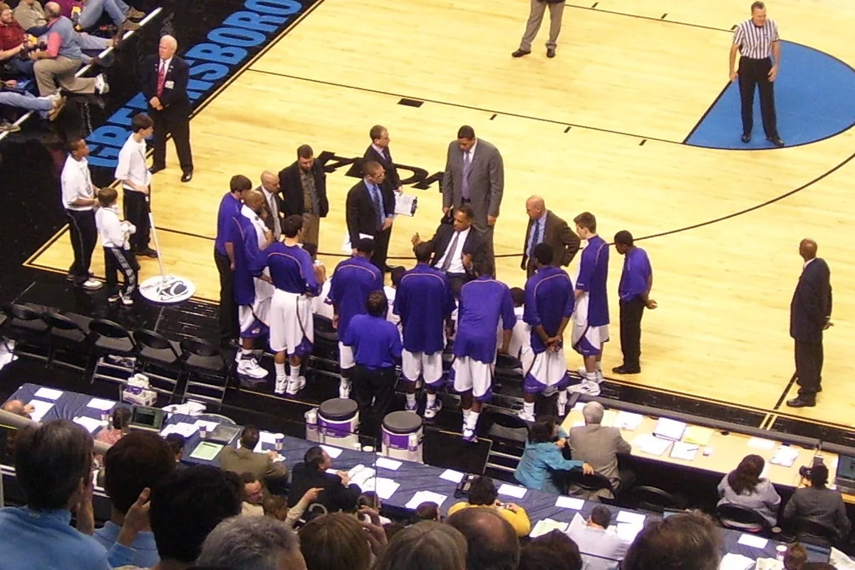 A coach giving instructions to a huddled team