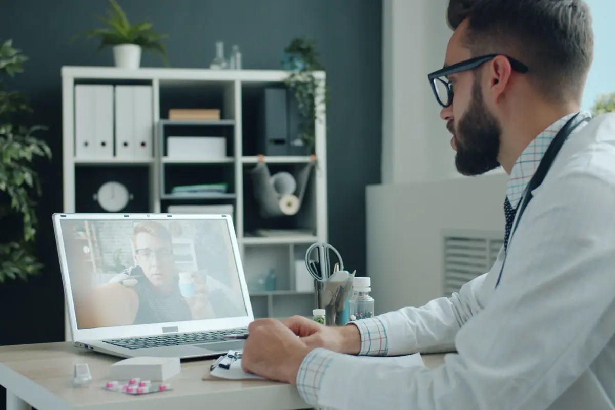 A clinician conducting a video consultation on a laptop
