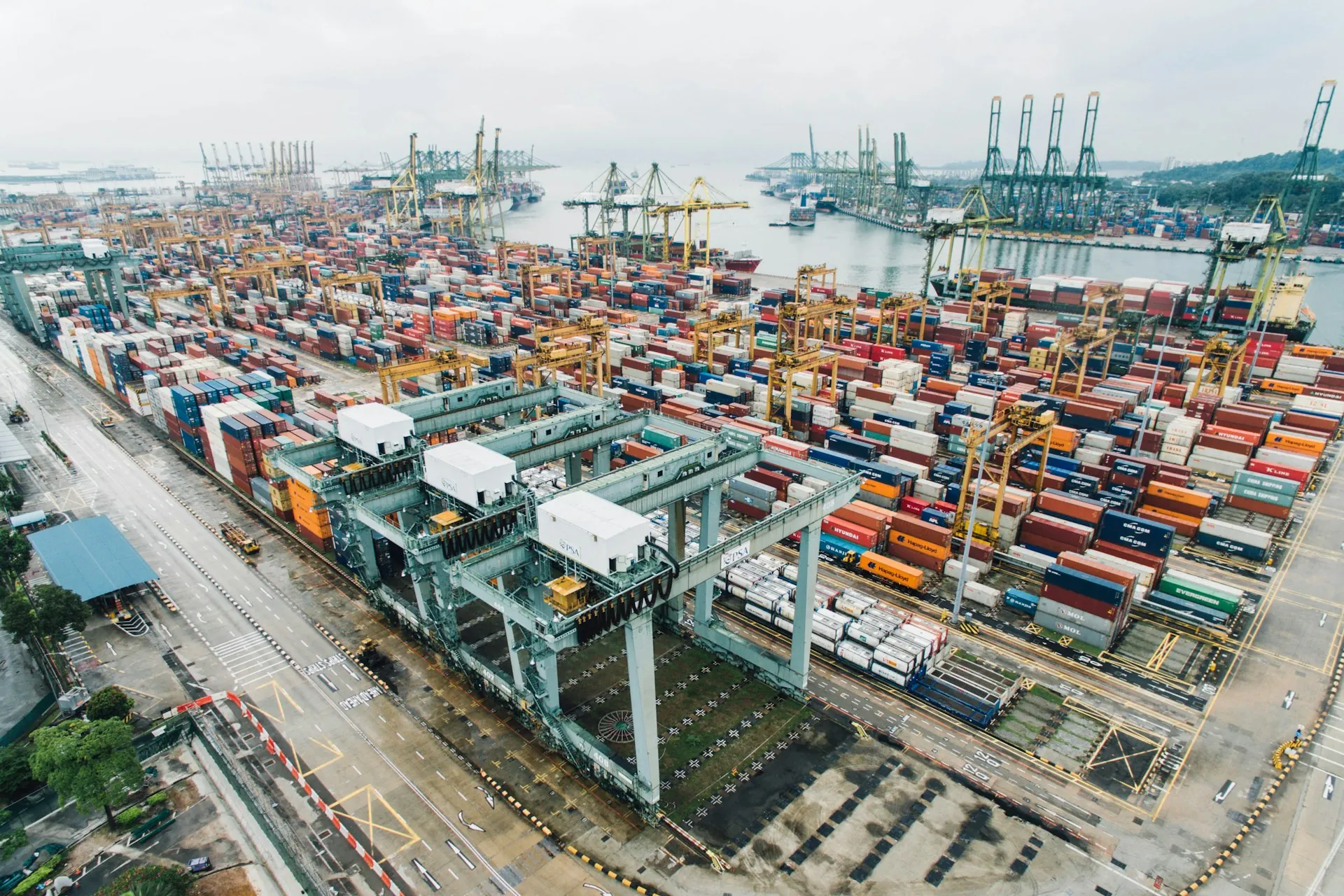 Container cranes and stacked shipping containers at a busy cargo port